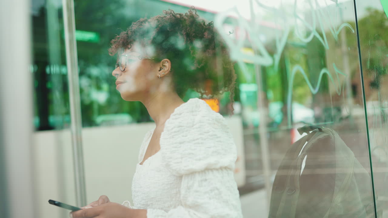 Woman Waiting at Bus Stop with Backpack
