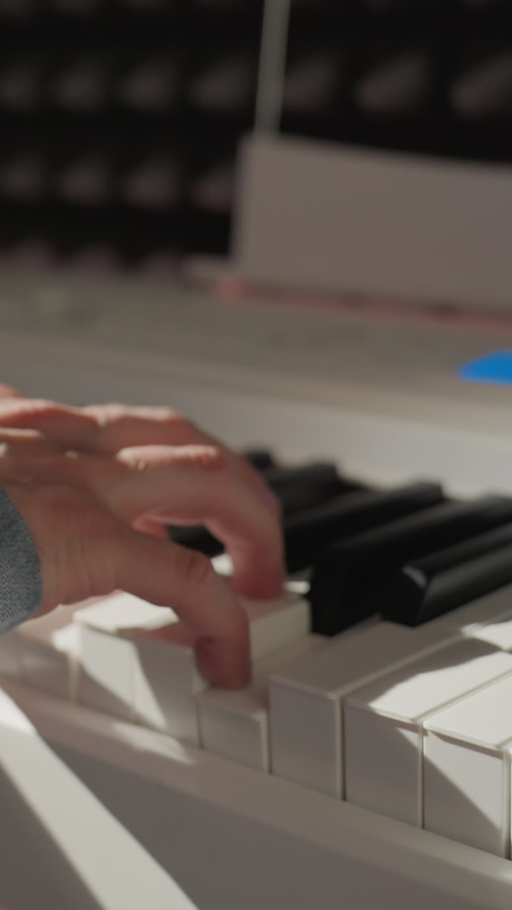 una foto elegante de una mano con una camisa de manga azul tocando el piano, con un fondo borroso que destaca el enfoque del artista