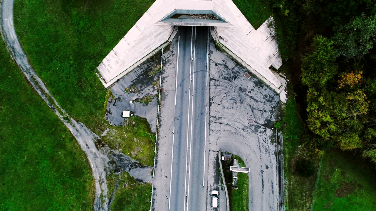 vista aérea sobre el túnel de la autopista de entrada en francia. sólo campos de hierba y árboles alrededor de las carreteras. coches y camiones conduciendo en las carreteras