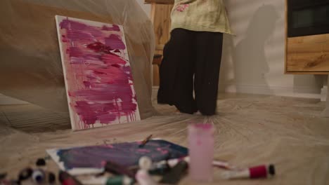 artist working on abstract painting in home studio