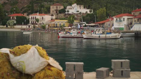 medium establishing view of leonidio greece harbor with boats anchored and mediterranean homes on hillside