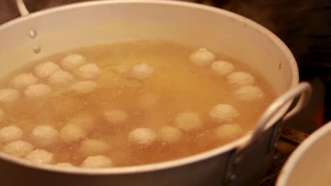 hand stirring dumplings in a large pot