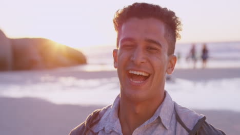 Retrato-De-Un-Hombre-Atractivo-Sonriendo-En-La-Playa-Al-Atardecer-En-Cámara-Lenta