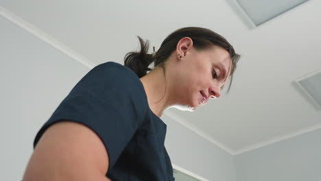 professional skin expert tilting head while massaging client with fingertips on massage bed in spa session room with white modern ceiling and soft ambient lighting conveying focused therapeutic care