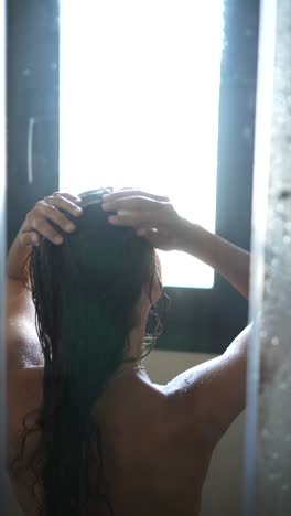 woman showering in bathroom near window