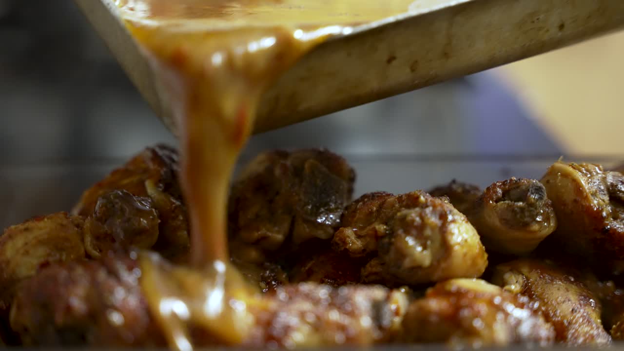 The culinary delight as a person pours savory sauce over succulent chicken pieces, tantalizingly preparing a mouthwatering meal, epitomizing the essence of culinary artistry and cuisine