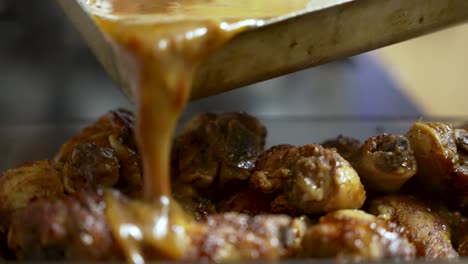 the culinary delight as a person pours savory sauce over succulent chicken pieces, tantalizingly preparing a mouthwatering meal, epitomizing the essence of culinary artistry and cuisine