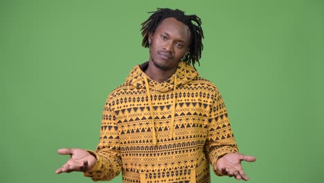 young handsome african man shrugging shoulders