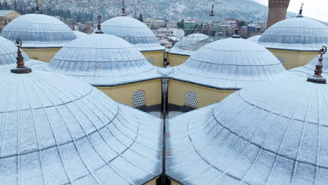 domes of grand mosque of bursa with snow in turkey - aerial drone shot