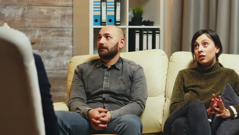 young man breathing heavily sitting on couch