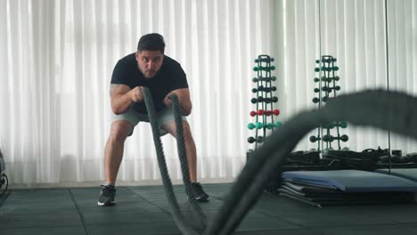 Man-Using-Battle-Ropes-For-Whipping-Exercise-in-a-Gym-in-slow-motion