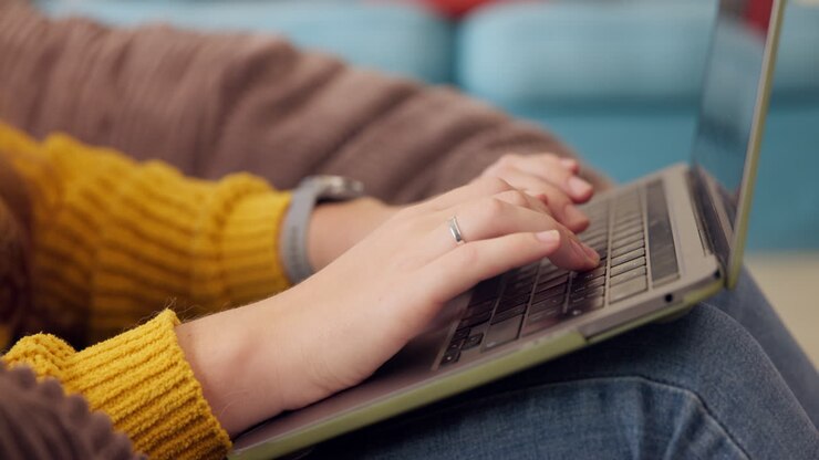 Hands typing on a laptop