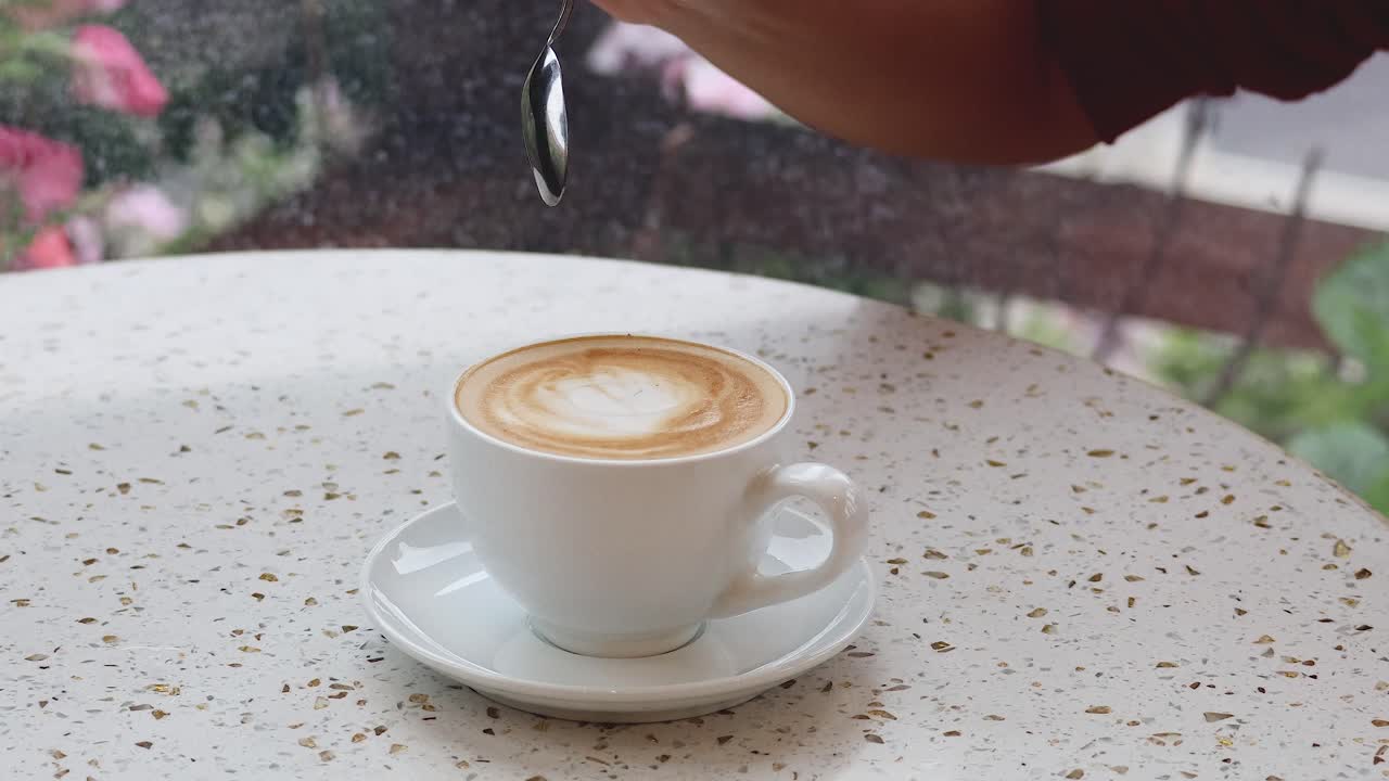 agitando el café a mano en una cafetería al aire libre