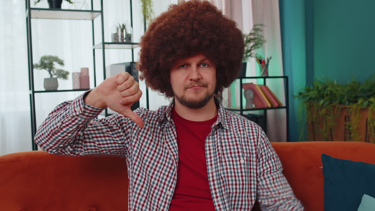 joven molesto mostrando pulgares hacia abajo, no le gusta el mal trabajo, desaprobación, retroalimentación insatisfecha en casa