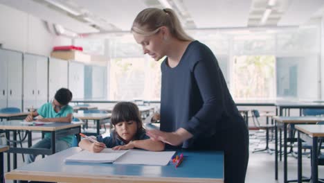 amable profesora de escuela explicando el ejercicio a su alumno