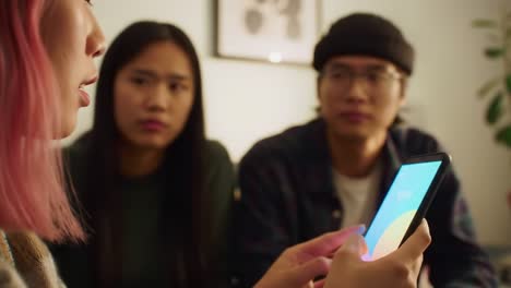 a group discussion on a mobile app's features: engaged friends analyzing a smartphone interface in a cozy, home environment