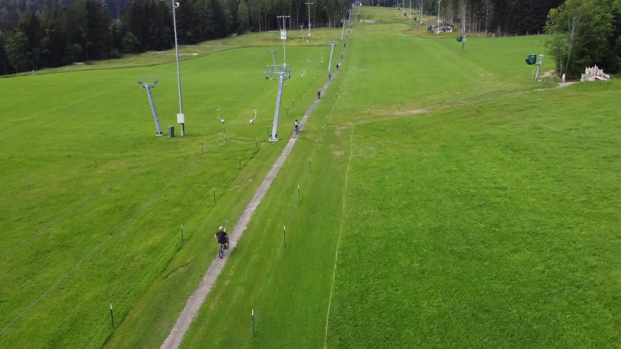 자전거 트레일 파크 의 드론  - 드론 은 많은 자전거 타는 사람 들 이 언덕 을 올라가는 엘리베이터  에 빠르게 날아간다
