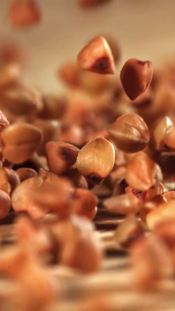 Buckwheat Grains Falling in Slow Motion onto a Wooden Surface