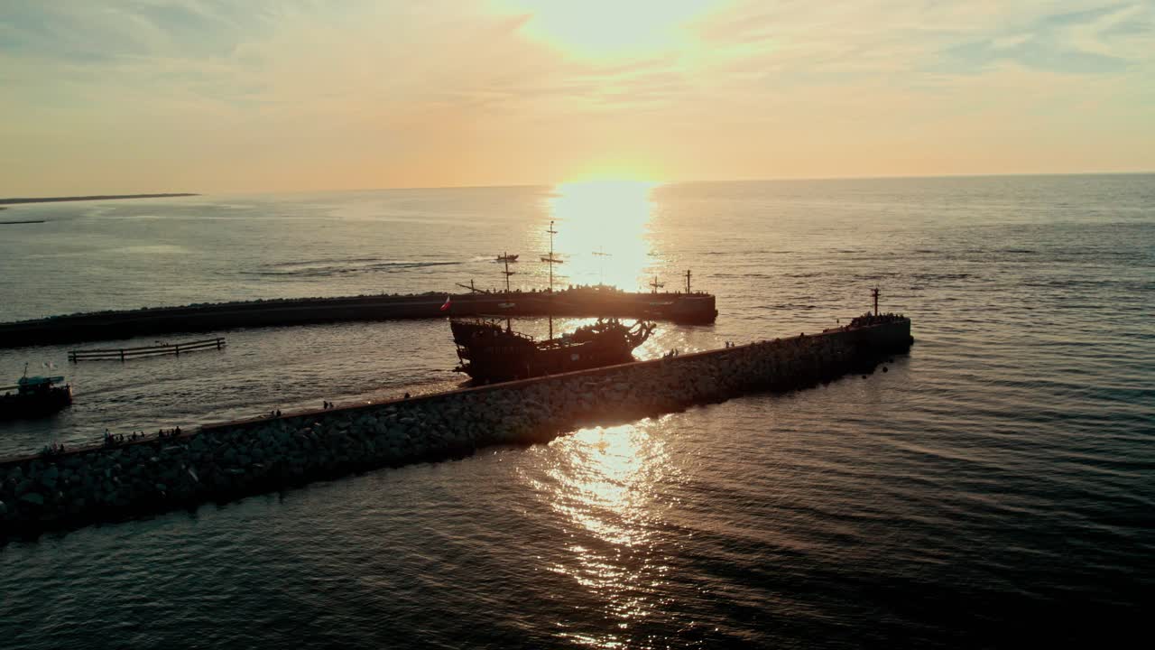 Sunset over the Ocean with a Galleon Ship at the Harbor