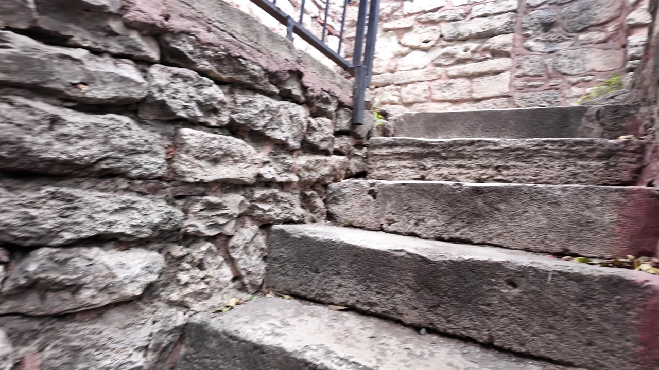 Slow Upward Pan of Old Stone Steps and Textured Wall
