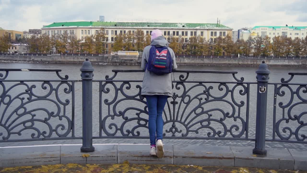 mujer mirando el río en una ciudad
