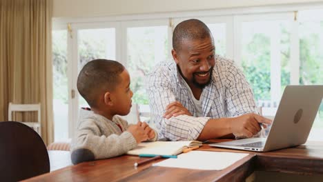 Father-and-son-using-laptop-in-living-room-4k