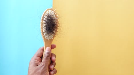 hand holding a hair brush with hair loss