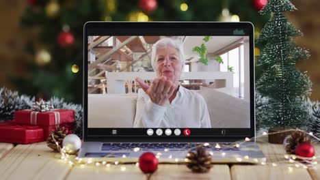 Feliz-Mujer-Mayor-Caucásica-En-Videollamada-En-Una-Computadora-Portátil,-Con-Adornos-Navideños-Y-árbol