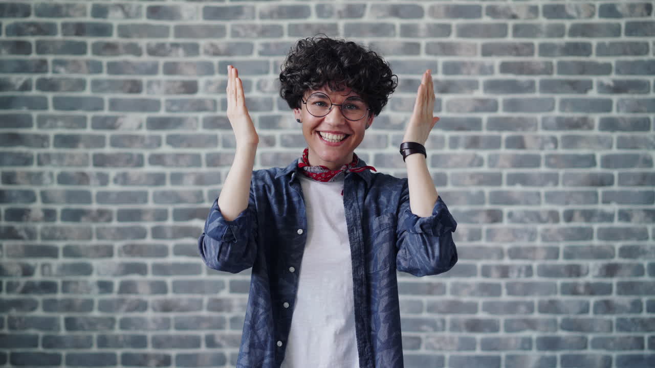 People with varied expressions in front of a brick wall