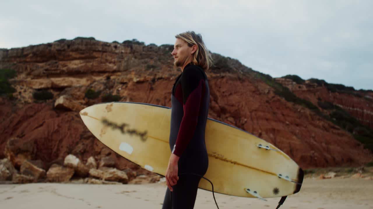 Man walking with surfboard on a beach