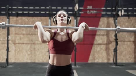 mujer levantando pesas en un gimnasio
