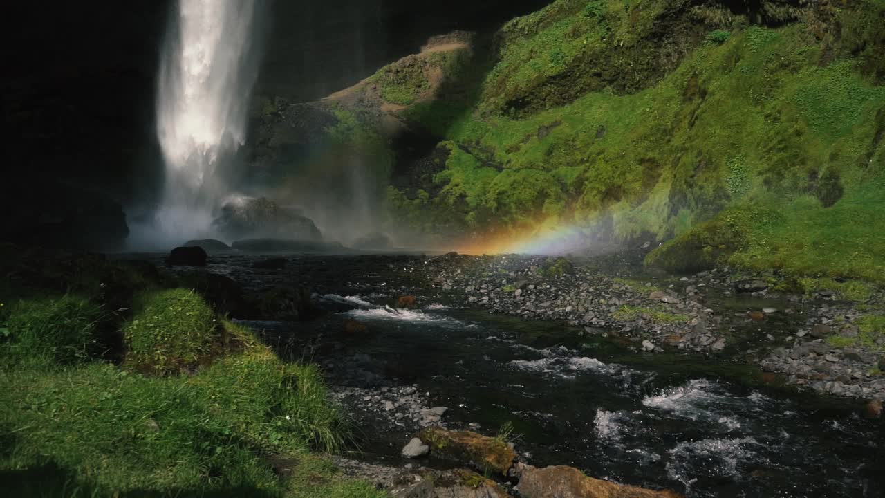 hombre tocando la guitarra frente a una hermosa cascada en islandia-26