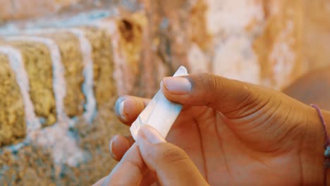 slow motion shot of somebody carefully preparing a cannabis spliff outside in the caribbean