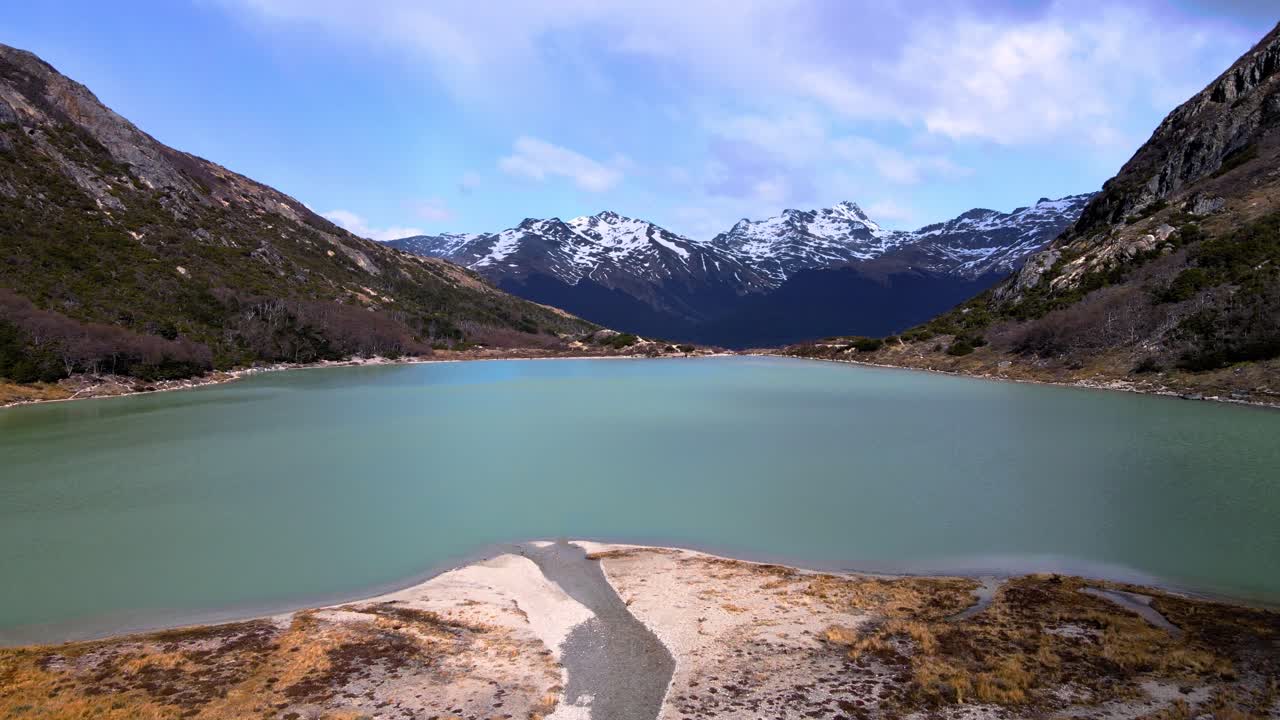 drone disparado volando sobre la laguna esmeralda cerca de ushuaia, argentina hacia las montañas de los andes