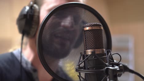 toma cinematográfica de micrófono de estudio y cantante, primer plano extremo