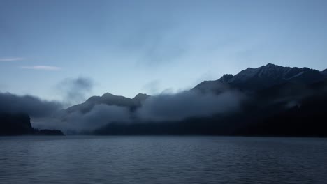 Sunrise-time-lapse-of-Lake-Sils-in-Engadin,-Switzerland-as-seen-from-Maloja-on-a-misty-morning-with-a-close-up-of-the-mountains