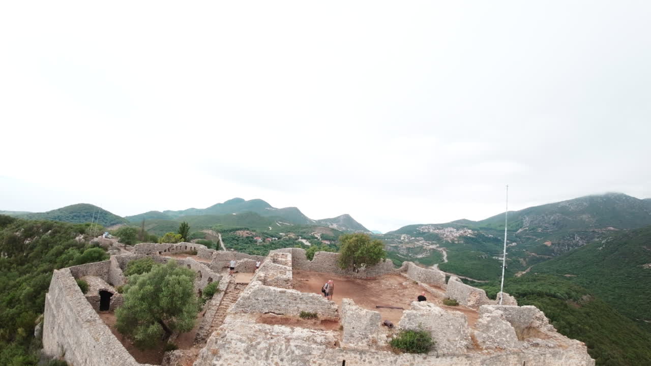 drone fpv volando sobre las antiguas ruinas del castillo en la cima de la montaña