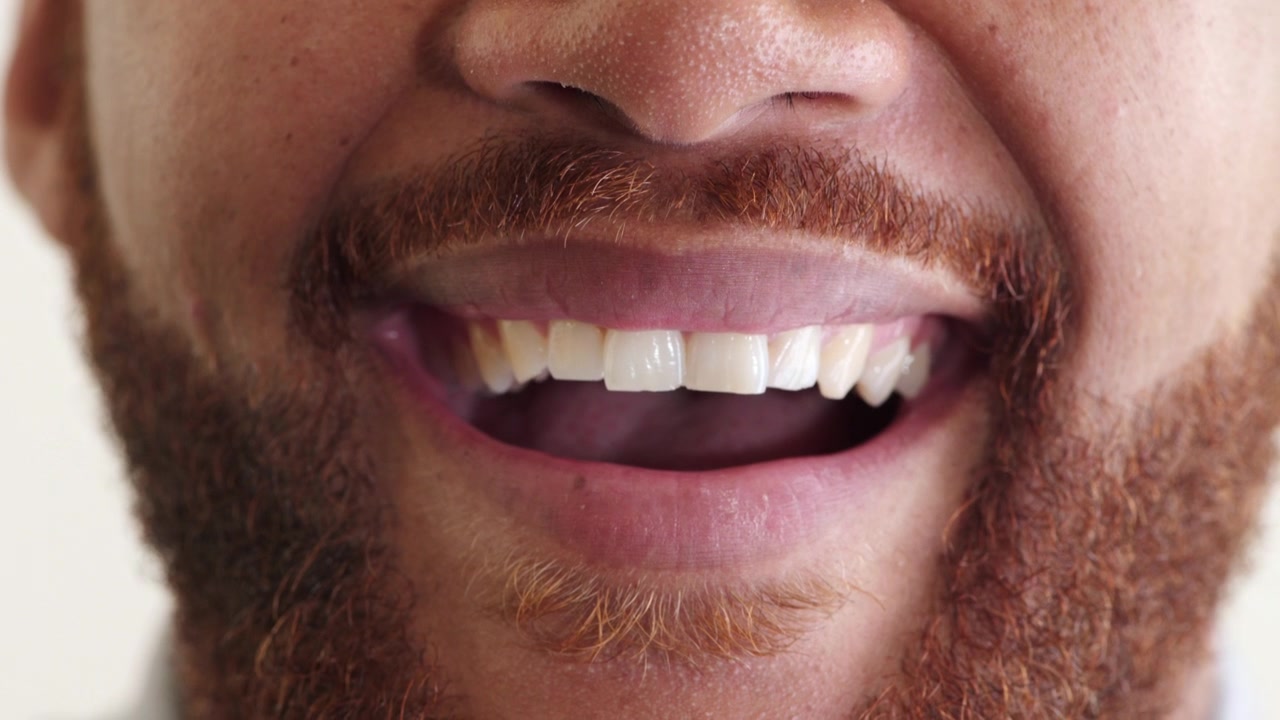 Close-up of a Man Smiling and Showing Teeth