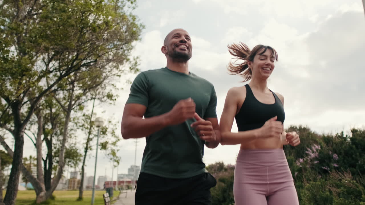 Happy Couple Jogging Together in a Green Urban Park
