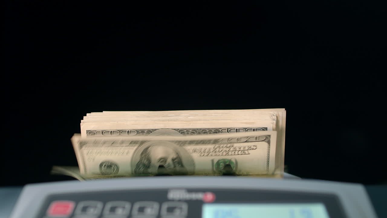 Banknote counter counting dollar bills. Money counting machine. Business success