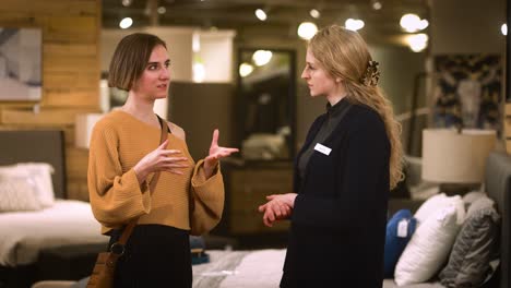 salesperson an customer in store, discussing products with gestures an listening