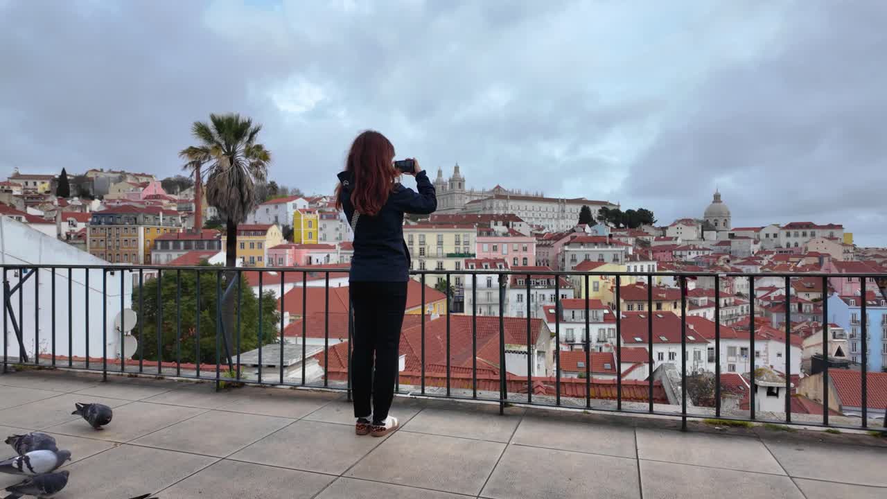 Slowmotion video of girl filming Lisbon landscape in Portugal