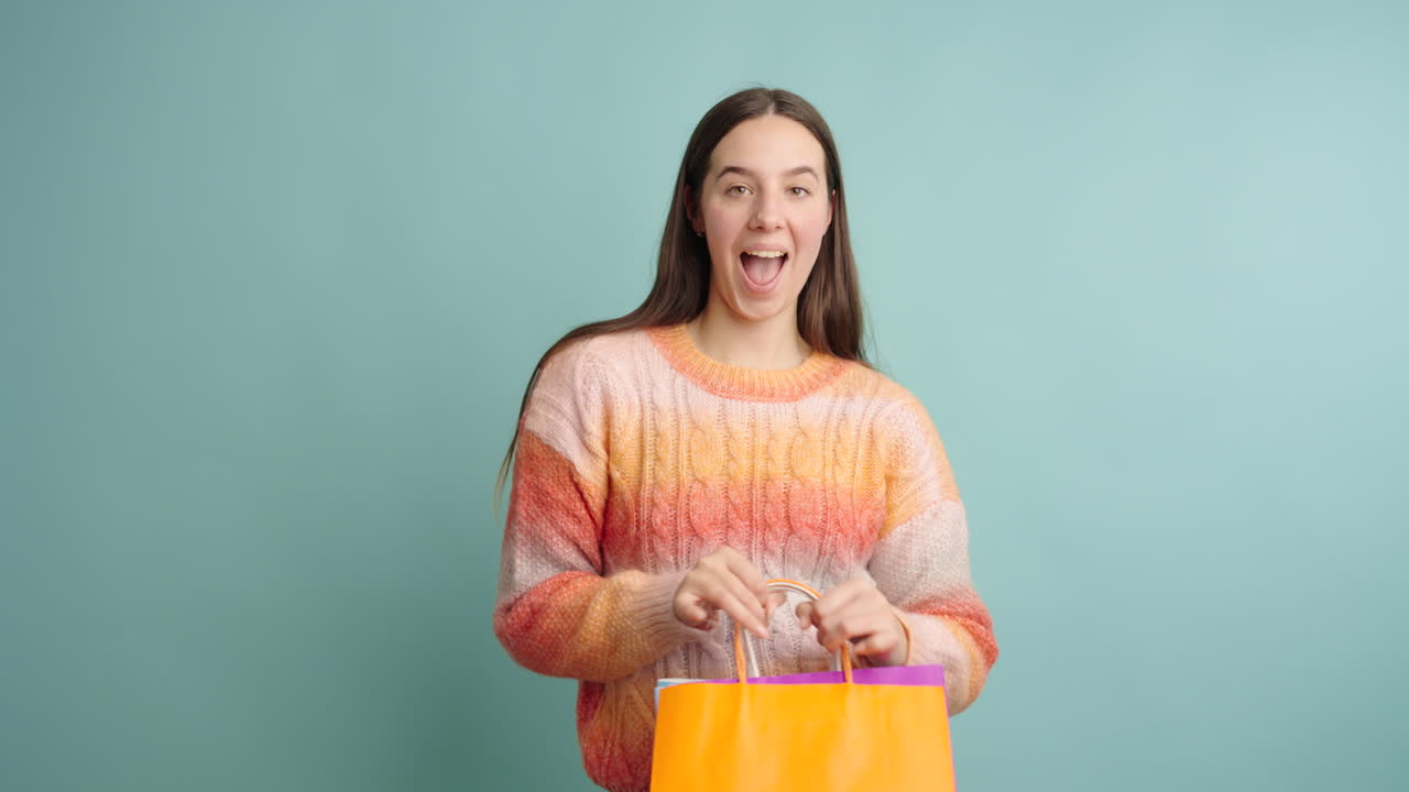 Young woman expressing happiness while holding shopping bags