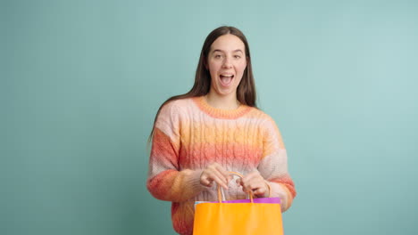 young woman expressing happiness while holding shopping bags