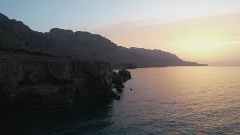 DRONE-SHOT-NEXT-TO-OCEAN-CLIFF-SIDE-AT-SUNRISE