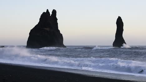 a rough winter sea with waves crashing on a black beech near vik in iceland