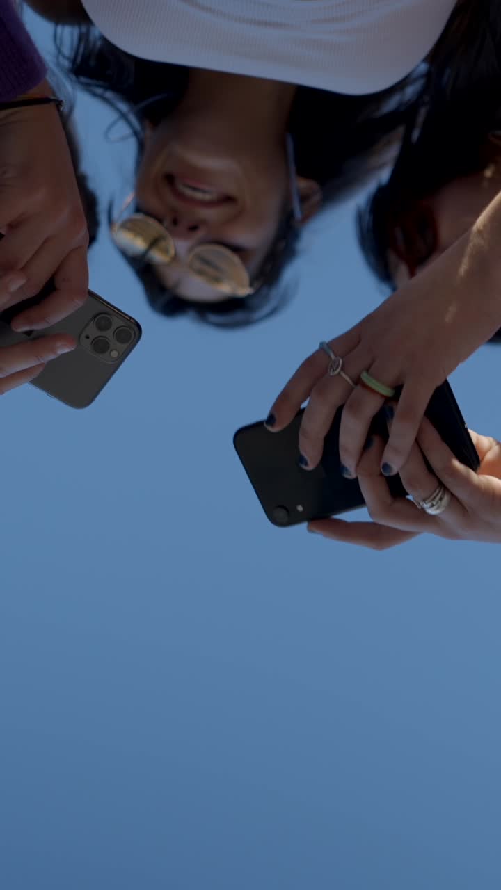 People holding smartphones against a blue sky