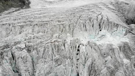 aerial flyover over the moiry glacier near grimentz in valais, switzerland with a pan up from the icy crevasses