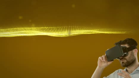 Kaukasischer-Mann-Mit-VR-Headset-Vor-Goldenen-Digitalen-Wellen-Und-Hellen-Flecken-Auf-Gelbem-Hintergrund