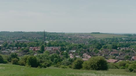 ciudad de grantham lincolnshire reino unido midlands orientales campos de cultivo vista en la distancia de la ciudad día de verano viento que sopla hierba y árboles y cultivos alto punto de vista casas a la vista y la iglesia de st wulfram